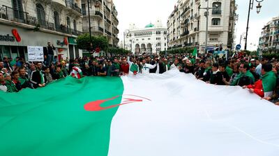 Algerians wave a giant national flag during an anti-government demonstration in the capital Algiers. AFP