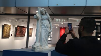 A man takes a photo of the white marble statue representing a woman leaning on a large cross located to his right, early 20th century at heritage exhibition entitled 'Our heritage is an inestimable wealth' in Tunis, Tunisia, 18 February 2022. 374 exhibited artifacts dating from ancient eras and civilizations, which Tunisia has managed to recover and seize these last years. These artifacts were selected from more than 40,000 pieces that were recovered and seized as part of the efforts of the National Heritage Institute in Tunisia between 2012 and 2019. EPA / MOHAMED MESSARA