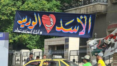 A banner in Bagdad street reads "Al Assad in my veins"