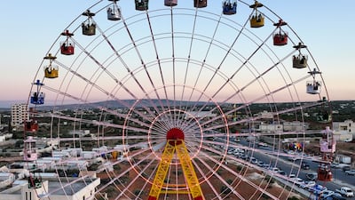 Revellers ride a Ferris wheel at an amusement park in Idlib, Syria, during Eid Al Adha. AFP