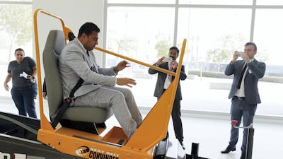 Ahmed Roshdy, from the hotel and transport group ADNH Compass, tries out a 'seat belt convincer', to show drivers and passengers how frightening a crash without a seat belt would be. Pawan Singh / The National