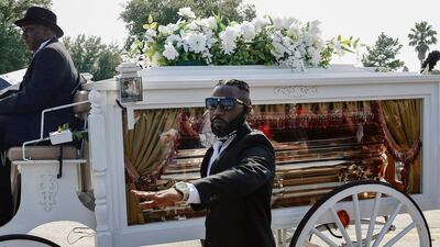 A man holds his hand up in solidarity as the body of George Floyd is brought by horse-drawn carriage in a funeral procession to Houston Memorial Gardens Cemetery for burial in Pearland, Texas. Getty Images