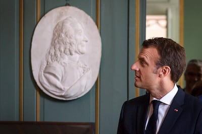The French philosopher Voltaire, depicted in a relief bust next to French President Emmanuel Macron, praised the Islamic world as a model of tolerance during his lifetime. AFP