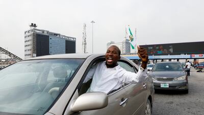 A demonstrator waves a Nigerian flag from a car window. Reuters