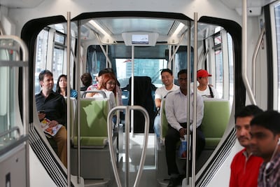 People ride on a Dubai Tram on the first day of its service in 2014. Pawan Singh / The National
