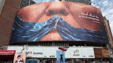 An Iranian man holds Iran’s national flag in front of a huge anti-US billboard referring to US president Donald Trump and Strait of Hormuz at Valiasr square in Tehran, Iran, 02 May 2026. The conflict between Iran and the United States over the Strait of Hormuz continues, as the ceasefire between the two countries has been extended indefinitely and diplomatic negotiations are ongoing. EPA / ABEDIN TAHERKENAREH