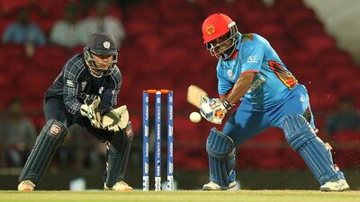 Afghanistan's Mohammad Shahzad (R) is watched by Scotland's wicketkeeper Matt Cross as he plays a shot during the ICC World T20 cricket tournament match between Afghanistan and Scotland at The Vidarbha Cricket Association Stadium in Nagpur on March 8, 2016. / AFP / STR