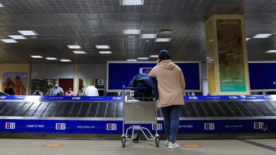 Passengers wearing protective face masks wait for their bags at the arrival area of Luxor International Airport, amid the coronavirus disease pandemic, in Luxor, Egypt. Reuters