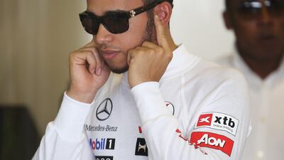 Lewis Hamilton, with father Anthony in the background, prepares for first practice at Yas Marina Circuit. Mark Thompson/Getty Images