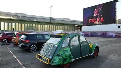 Visitors in a vintage Citroen 2CV car attend a drive-in live broadcast of the Berlin State Opera on the former airfield of Tempelhof Airport in Berlin, Germany. Getty Images