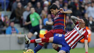 Barcelona’s Luis Suarez shoots and scores their second goal to go 2-1 up against Atletico Madrid on Saturday in La Liga. Alejandro Garcia / EPA