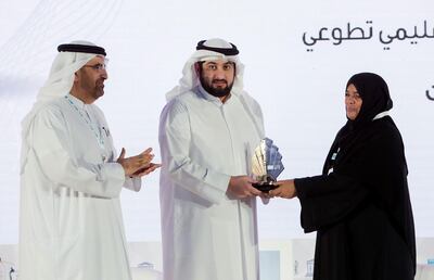 Zahra Al Aufi receives the Literacy Challenge Award from Jamal bin Dewari. Ruel Pableo for The National
