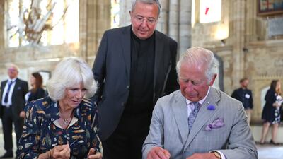 Camilla and Charles sign the visitors book at the cathedral.
