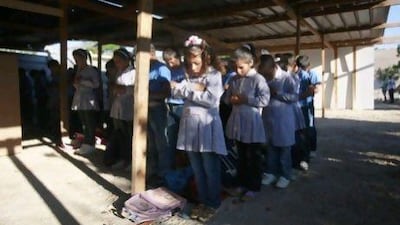 Palestinian bedouin students pray at their school at Khan Al Ahmar, near the West Bank city of Jericho, Their school is a collection of buildings made of mud and old tyres built despite objections of Israeli authorities.