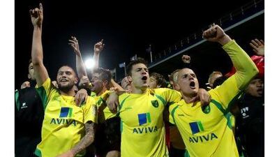 Norwich City celebrate promotion after the final whistle against Portsmouth on Monday.