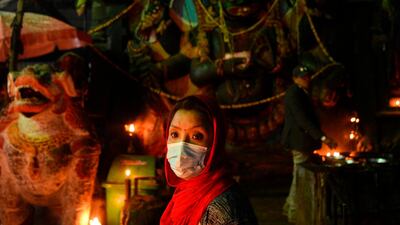 A Hindu woman wears a facemask as a preventive measure against the coronavirus while visiting Durbar Square to workship in Kathmandu. AFP