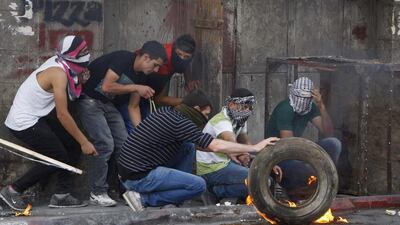 Palestinian protesters take up position during clashes with Israeli troops following a rally to show solidarity with Palestinian prisoners held in Israeli jails, in the West Bank city of Hebron. Mussa Qawasma / Reuters