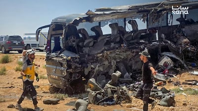 People and first responders inspect the damage after a collision of two passenger buses on the Deir Ezzor-Damascus road. AFP