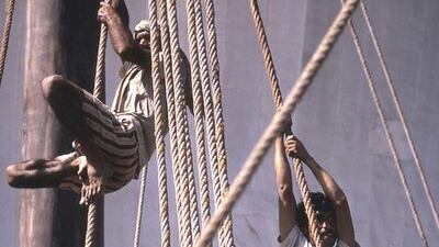 The crew scale the rigging to help secure the sail’s halyard and mast stays.