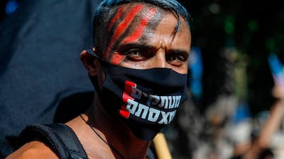 A face-painted Israeli protester wearing a protective mask amid the Covid-19 pandemic poses for a picture during a rally against Israeli Prime Minister Benjamin Netanyahu outside his official residence in Jerusalem, on July 17, 2020. AFP