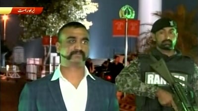 Wing Commander Abhinandan Varthaman stands under armed escort near Pakistan-India border in Wagah, Pakistan. PTV via Reuters