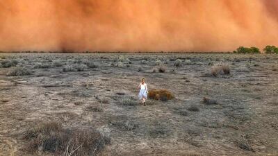 A child runs towards a dust storm in Mullengudgery in New South Wales. Dust storms hit many parts of Australia's western New South Wales as a prolonged drought continues. AFP