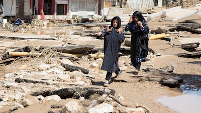 An Iranian woman walks through a flooded street in the city of Poldokhtar in the Lorestan province. AFP