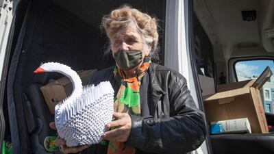 Galina Yakovleva stands by her van with an origami swan she made. AP Photo
