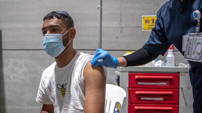 Mirza Zaib, from Pakistan, gets vaccinated at Biogenix Labs G42 in Masdar City. Victor Besa / The National