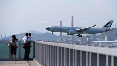 A Cathay Pacific jet prepares to land at Hong Kong's international airport. The carrier will cut jobs as it looks to pare costs. Dale de la Rey / AFP