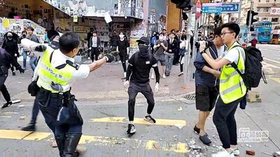 A still image from a social media video shows a police officer aiming his gun at a protester in Sai Wan Ho, Hong Kong, China November 11, 2019. Cupid Producer via Reuters.