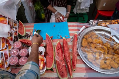 A seller cuts and packages watermelon for iftar in old Dubai. Antonie Robertson / The National