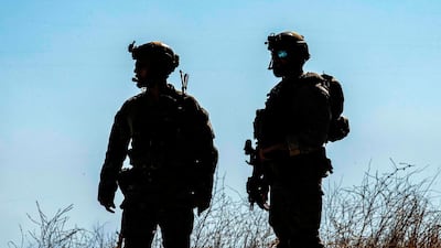 US soldiers stand during a patrol near an oil well in Rumaylan (Rmeilan) in Syria's northeastern Hasakeh province. AFP