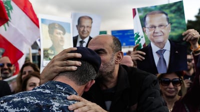 A backer of the Free Patriotic Movement founded by Lebanese President Michel Aoun (pictures), kisses the head of a policeman as he takes part in a rally on a road leading to the presidential palace in Baabda near the capital Beirut. AFP