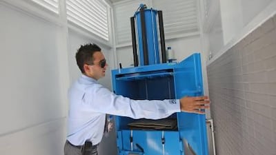 Mil-tek Middle East LLC export sales executive Darren Laird demonstrates the model 305 baler installed in the new Enoc petrol station, which compresses recyclable rubbish such as cardboard from inventory shipments.