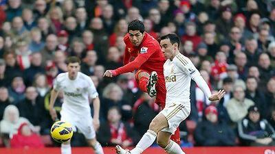 Swansea City's Leon Britton, centre right, attempts to block a shot by Liverpool's Luis Suarez, centre, during the Barclays Premier League match at Anfield, Liverpool, Sunday Feb. 17, 2013. (AP Photo/ David Davies, PA) UNITED KINGDOM OUT NO SALES NO ARCHIVE *** Local Caption *** Britain Soccer Premier League .JPEG-028da.jpg