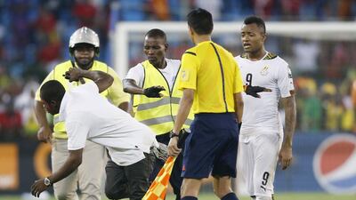 Security stop an Equatorial Guinea fan on the pitch as he tries to attack the referee during the 2015 African Cup of Nations semi-final soccer match against Ghana in Malabo, February 5, 2015. Violent scenes overshadowed the African Nations Cup semi-final as Ghana reached Sunday?s final with a 3-0 win over hosts Equatorial Guinea on Thursday in a match halted for 34 minutes late in the second half. REUTERS/Amr Abdallah Dalsh