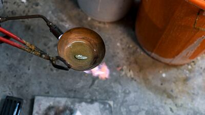 The melting process to make a gold bar at the studio in Mussafah.