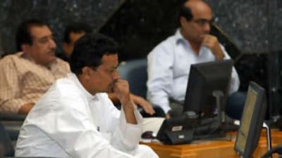 Traders on the floor of Abu Dhabi Securities Exchange watch the market slide.