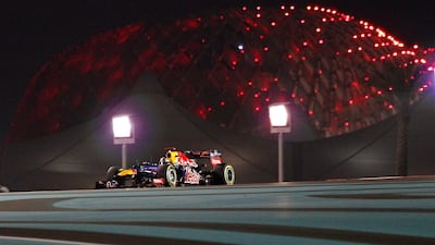 The lights of Yas Marina Circuit form a dramatic background as Sebastian Vettel navigates round the circuit in his Red Bull. Ali Haider/EPA