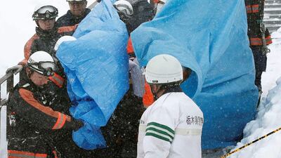 Rescue workers carry victims after an avalanche hit a group of high school students and teachers climbing near a ski resort in Nasu, a Japanese town north of Tokyo, on March 27, 2017. Kyodo via Reuters