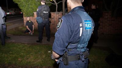 A handout photo taken on September 18, 2014, shows Australian federal police officers detaining a suspect in Sydney in Australia's largest ever counter-terrorism raids which arrested 15 people. AFP Photo
