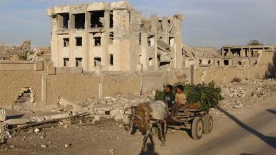 Residents drive a cart in front of a building damaged by a US-led air strike in ISIL-controlled Raqqa on November 1, 2014. Around 5,000 Syrian passports have gone missing from government offices in Raqqa and Deir Ezzour since they were captured by the extremist group. Stringer/Reuters