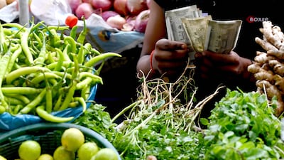 A vegetable seller counts Indian rupee notes in Mumbai, India. AFP