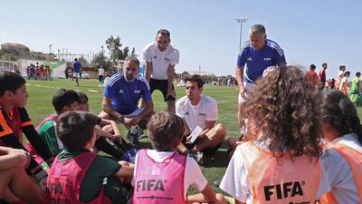 Former AC Milan and Real Madrid midfielder Kaka and ex-France international Youri Djorkaeff talk to school pupils. AFP