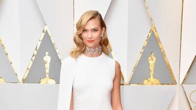 Model Karlie Kloss teamed her sleek caped white dress with a Roger Vivier clutch. The detailing on the handle and her elaborate choker offset the simplicity of the dress. Courtesy Roger Vivier
