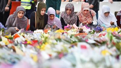 Young Muslim women lay flowers at a makeshift memorial near the scene of a fatal siege in the heart of Sydney's financial district on December 16, 2014. Peter Parks/AFP PHOTO