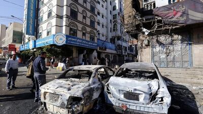 Yemenis walk past destroyed vehicles at a street leading to the residence of Yemen’s ex-president Ali Abdullah Saleh a day after Houthi militants killed him, in Sana’a, Yemen. Yahya Arhab / EPA