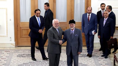 Iranian Foreign Minister Mohammad Javad Zarif, left in foreground, and his Omani counterpart Yousuf bin Alawi shake hands while posing for a photo prior to their meeting, in Tehran, Iran. AP Photo