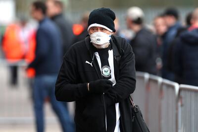 A Newcastle United fan with a face mask in preparation in the control of the coronavirus outside the ground before the Premier League match at St Mary's Stadium, Southampton. PA